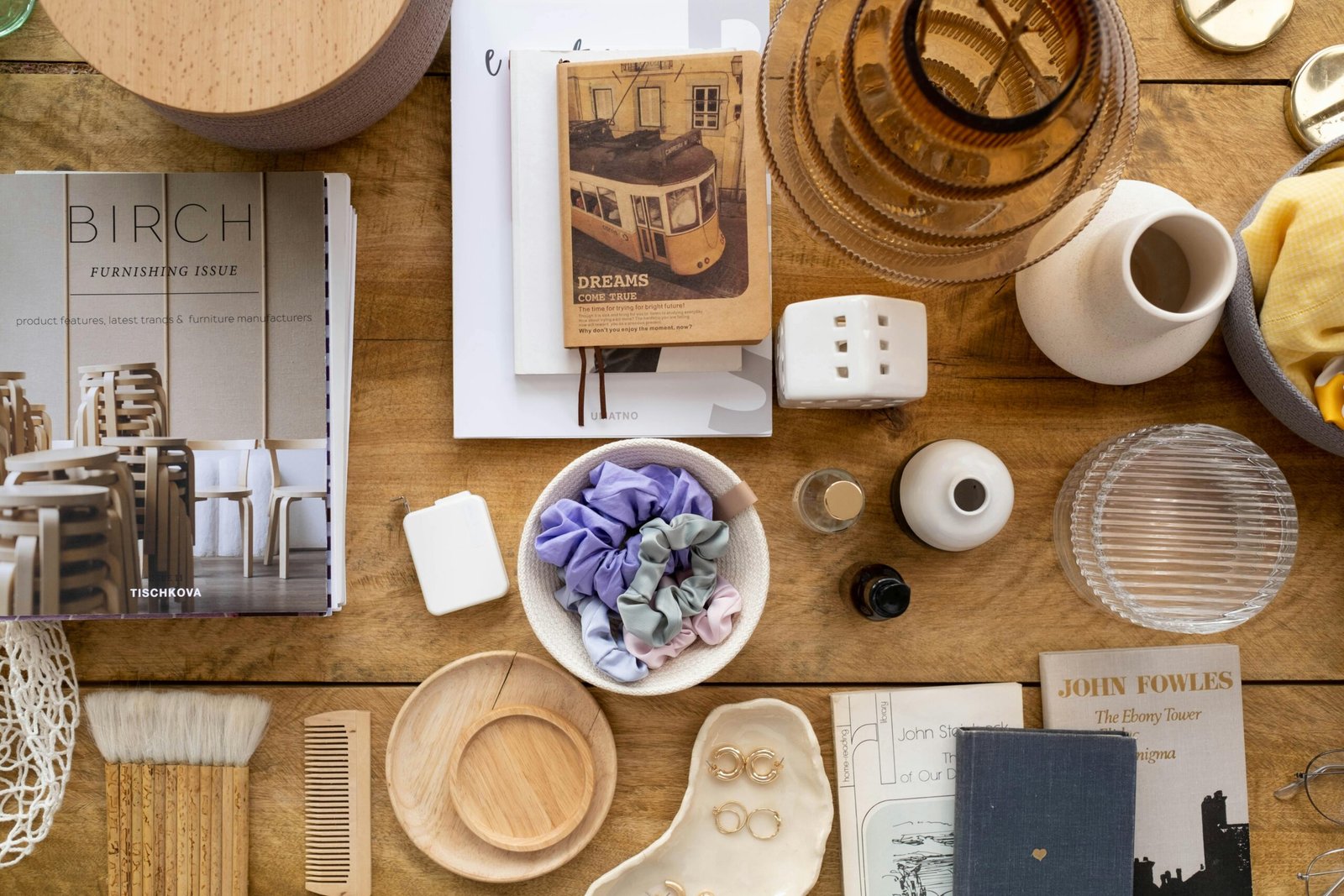 pexels-photo-8274739-8274739 A chic arrangement of books, accessories, and decor items on a wooden table, captured in a top-down view.